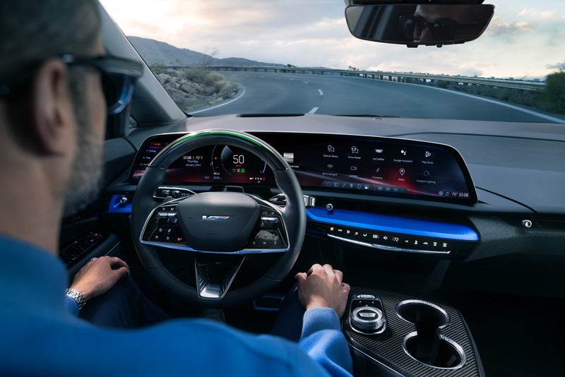 Front View of the 2026 OPTIQ-V Driving Through the Dusk Utilizing its Headlights | Coleman Cadillac in LAWRENCEVILLE NJ